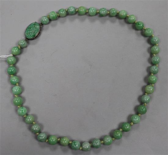 A single strand jadeite bead necklace, with carved jadeite clasp, 42cm.